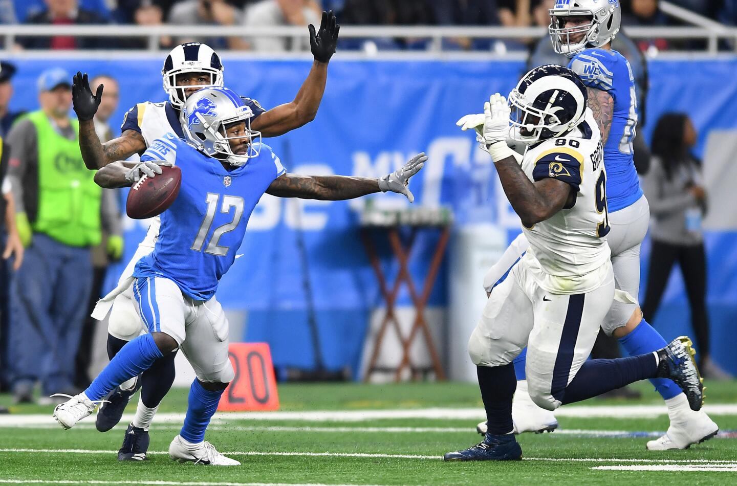 Detroit Lions receiver Bruce Ellington tries to throw a pass but is swarmed by Rams' Marcus Peters, left, and Michael Brockers and forced into an incomplete pass in the third quarter at Ford Field in Detroit on Sunday.