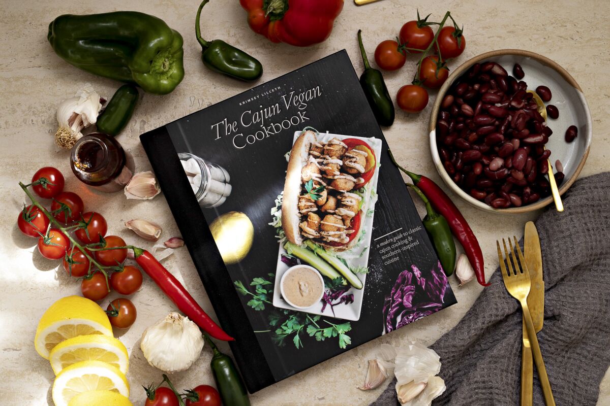 "The Cajun Vegan Cookbook" on a table surrounded by vegetables