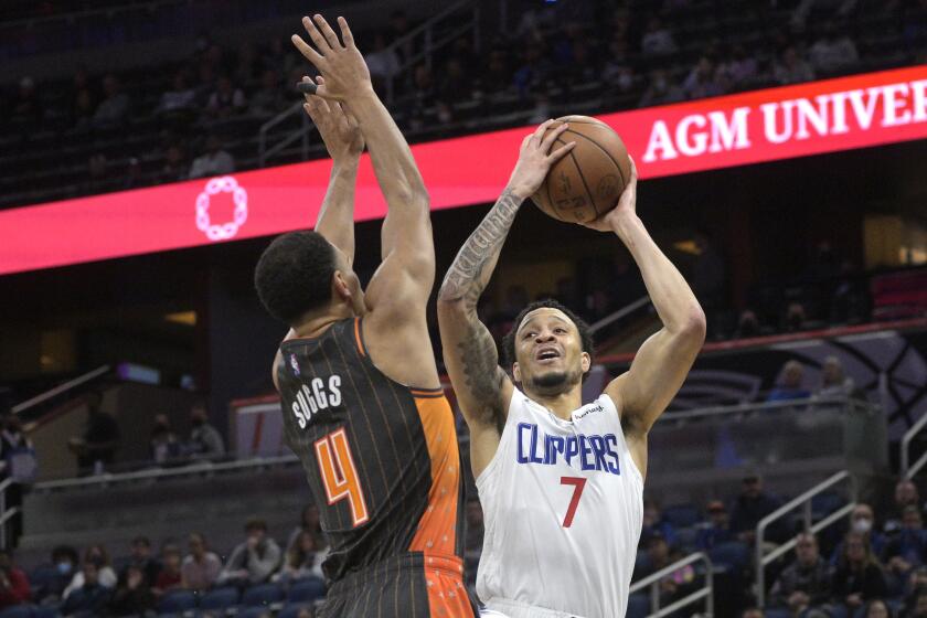 Los Angeles Clippers guard Amir Coffey (7) goes up for a shot in front of Orlando Magic guard Jalen Suggs (4) during the first half of an NBA basketball game, Wednesday, Jan. 26, 2022, in Orlando, Fla. (AP Photo/Phelan M. Ebenhack)