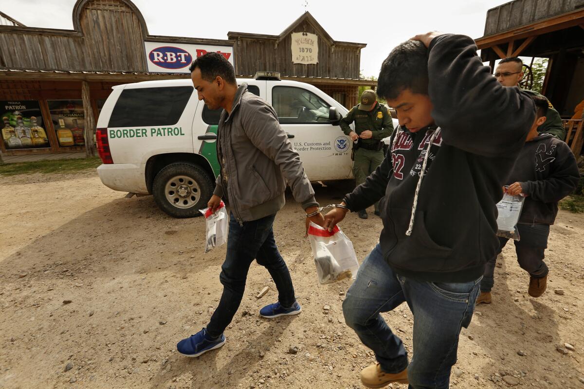 U.S. Border Patrol agents take 13 migrants into detention in the border town of Los Ebanos, Texas.