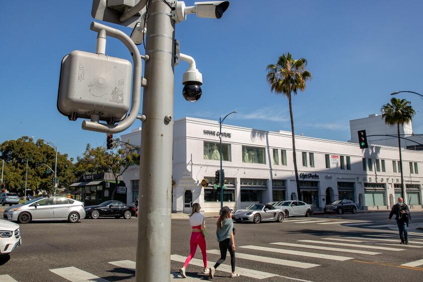 Security cameras are attached to a pole at the intersection of Santa Monica Blvd. and Beverly Dr. in Beverly Hills.