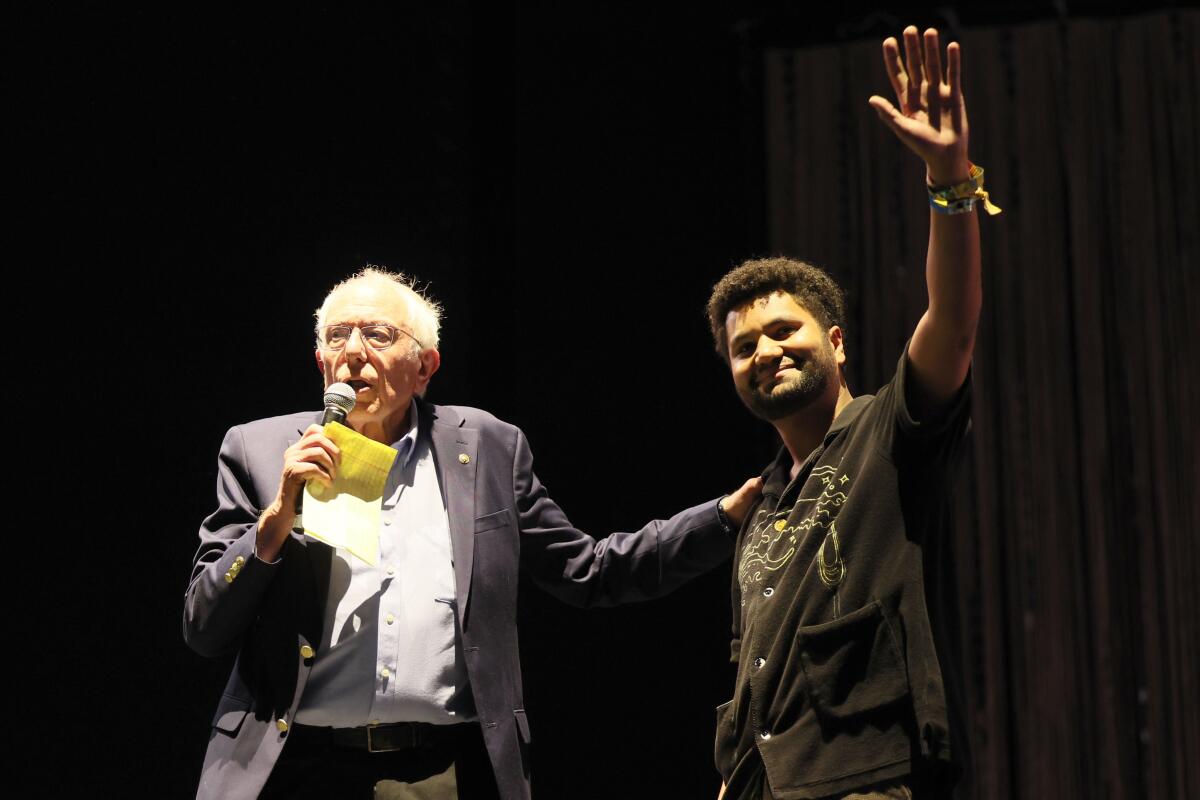 Sen. Bernie Sanders, left, and Rep. Maxwell Frost astatine the Coachella euphony festival successful Indio.