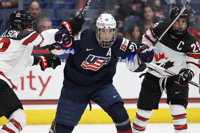 FILE - In this Dec. 14, 2019, file photo, Canada's Meaghan Mikkelson (12) and Marie-Philip Poulin (29) defends.