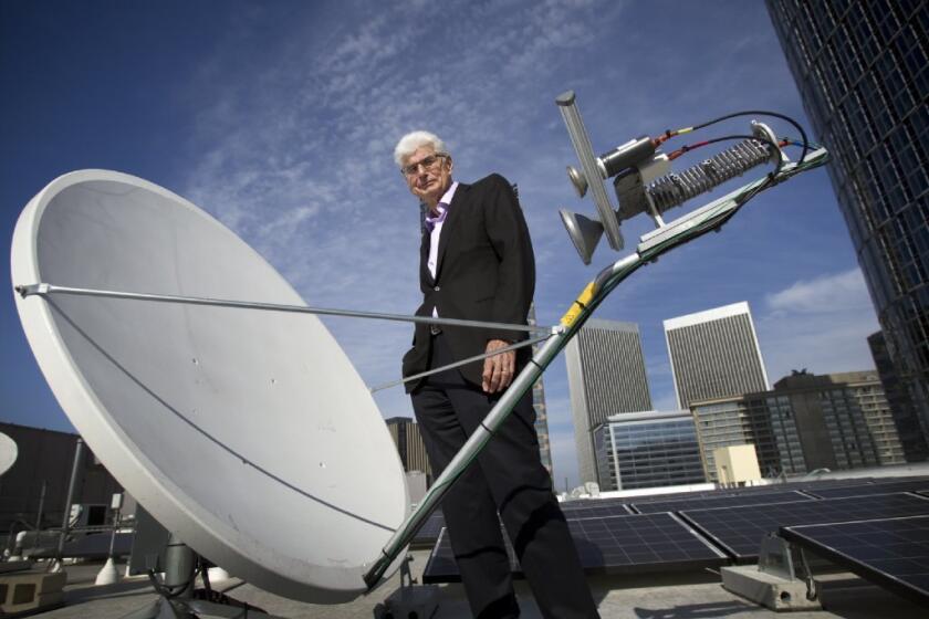 Randy Blotky, CEO of the Digital Cinema Distribution Coalition, stands by a satellite dish on the roof at the AMC Century City 15 theater. The satellite network significantly reduces the price of showing movies in theaters.