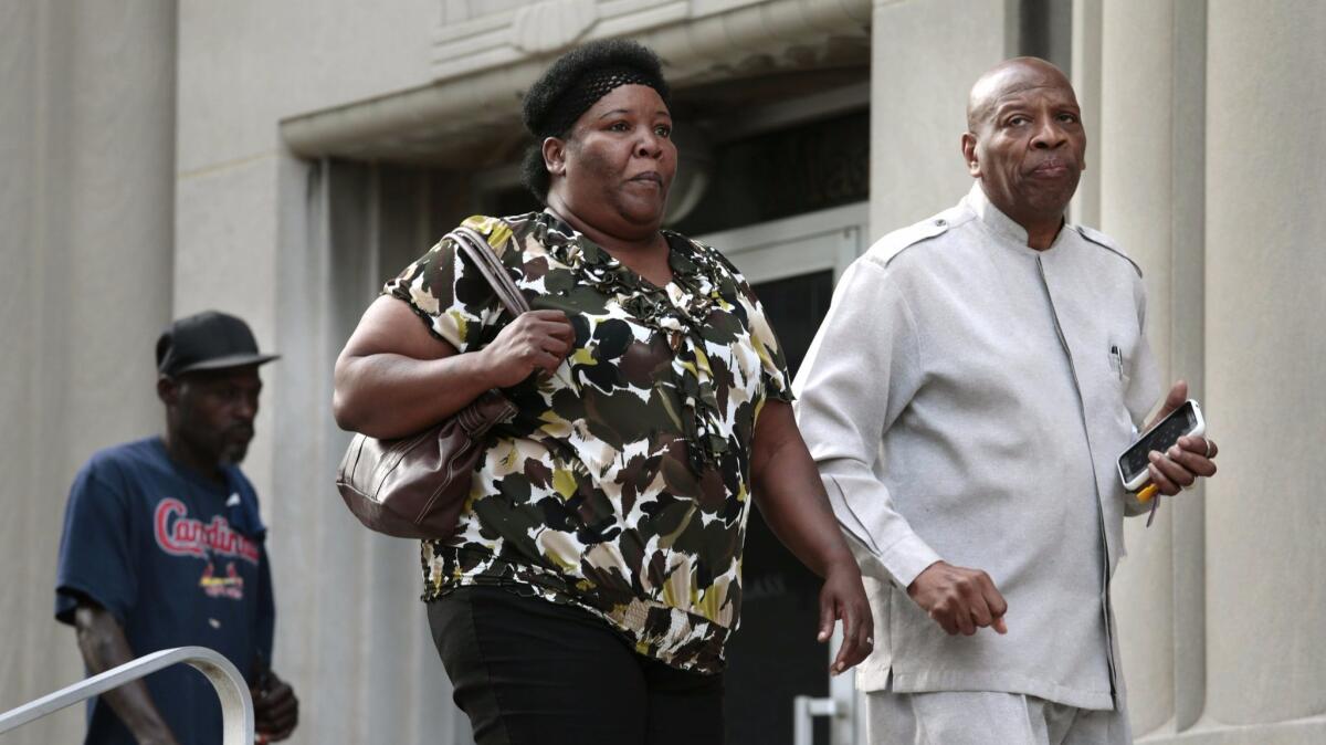 Annie Smith, the mother of Anthony Lamar Smith, enters the Carnahan courthouse with activist Anthony Shahid for opening statements in the trial of former St. Louis police officer Jason Stockley.