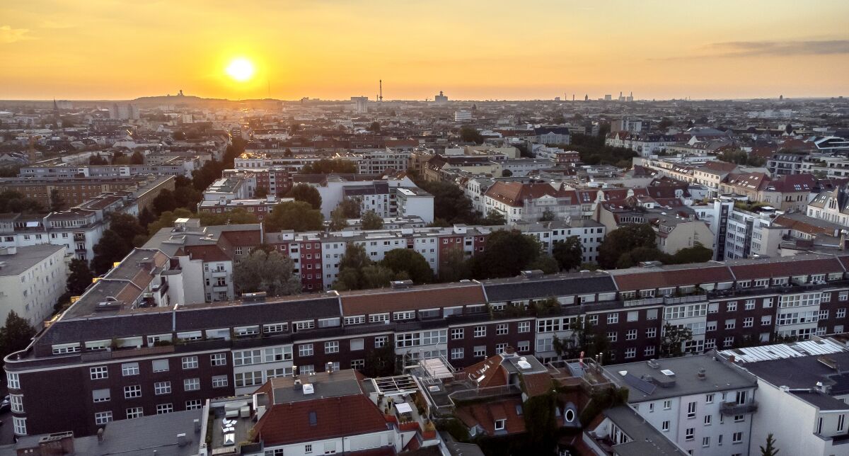 FILE - In this Sept. 7, 2021 file photo the sun goes down behind apartment houses in Berlin, Germany. Berlin's city government said Friday it is buying some 14,750 apartments from two large corporate landlords for 2.46 billion euros ($2.9 billion) — a deal announced a week before local and national elections as the German capital tries to expand the supply of publicly owned accommodation. (AP Photo/Michael Sohn, File)