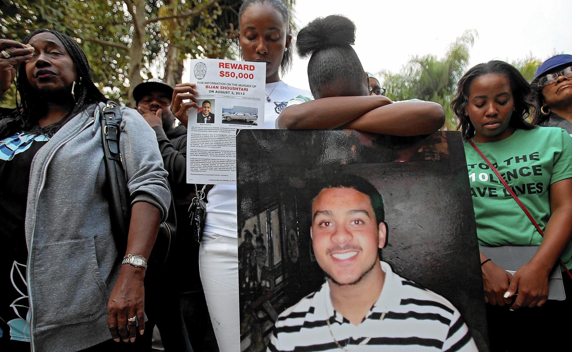 Mourners carry a photo of a man who was killed