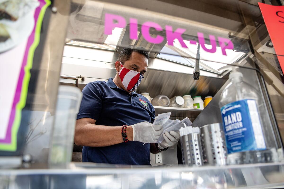Albert Hernandez, owner of Alebrije’s taco truck, shuffles through receipts. Although business has declined by half while costs have increased, he refuses to raise prices.