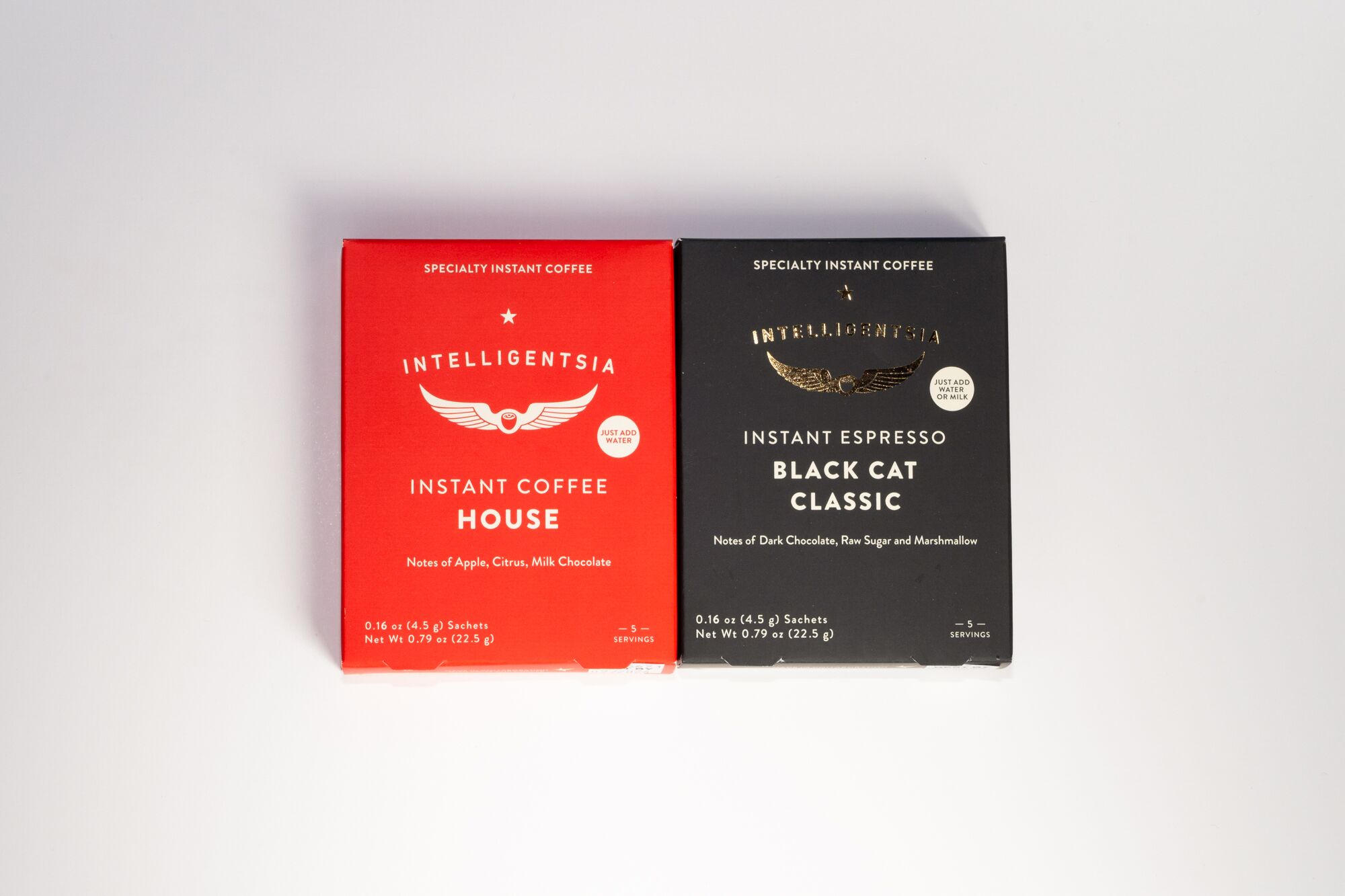 A red box and a black box of Intelligentsia Coffee, side by side