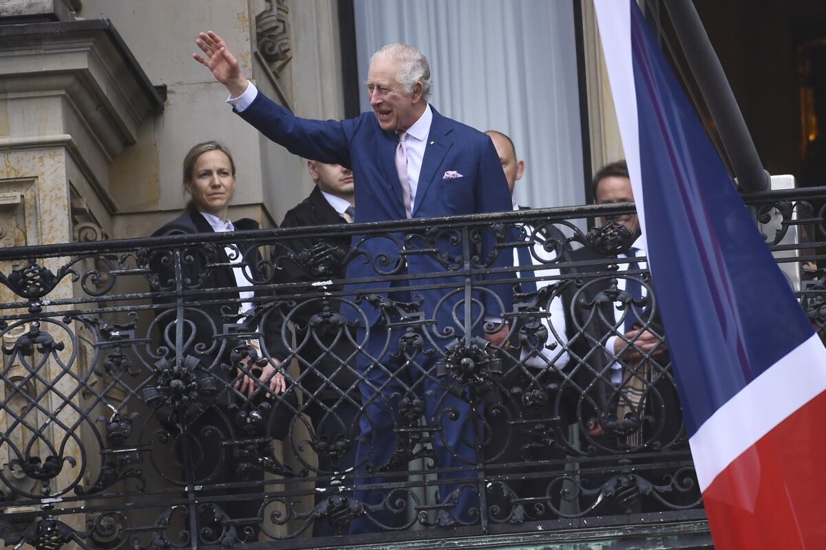 FILE - Britain's King Charles III waves from a balcony of the city hall in Hamburg, Germany, Friday, March 31, 2023. King Charles III won plenty of hearts during his three-day visit to Germany, his first foreign trip since becoming king following the death of his mother, Elizabeth II, last year. (AP Photo/Gregor Fischer, File)