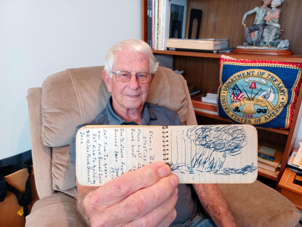 Ray Calloway holds up a notebook with a sketch of an atomic blast he witnessed in 1952.