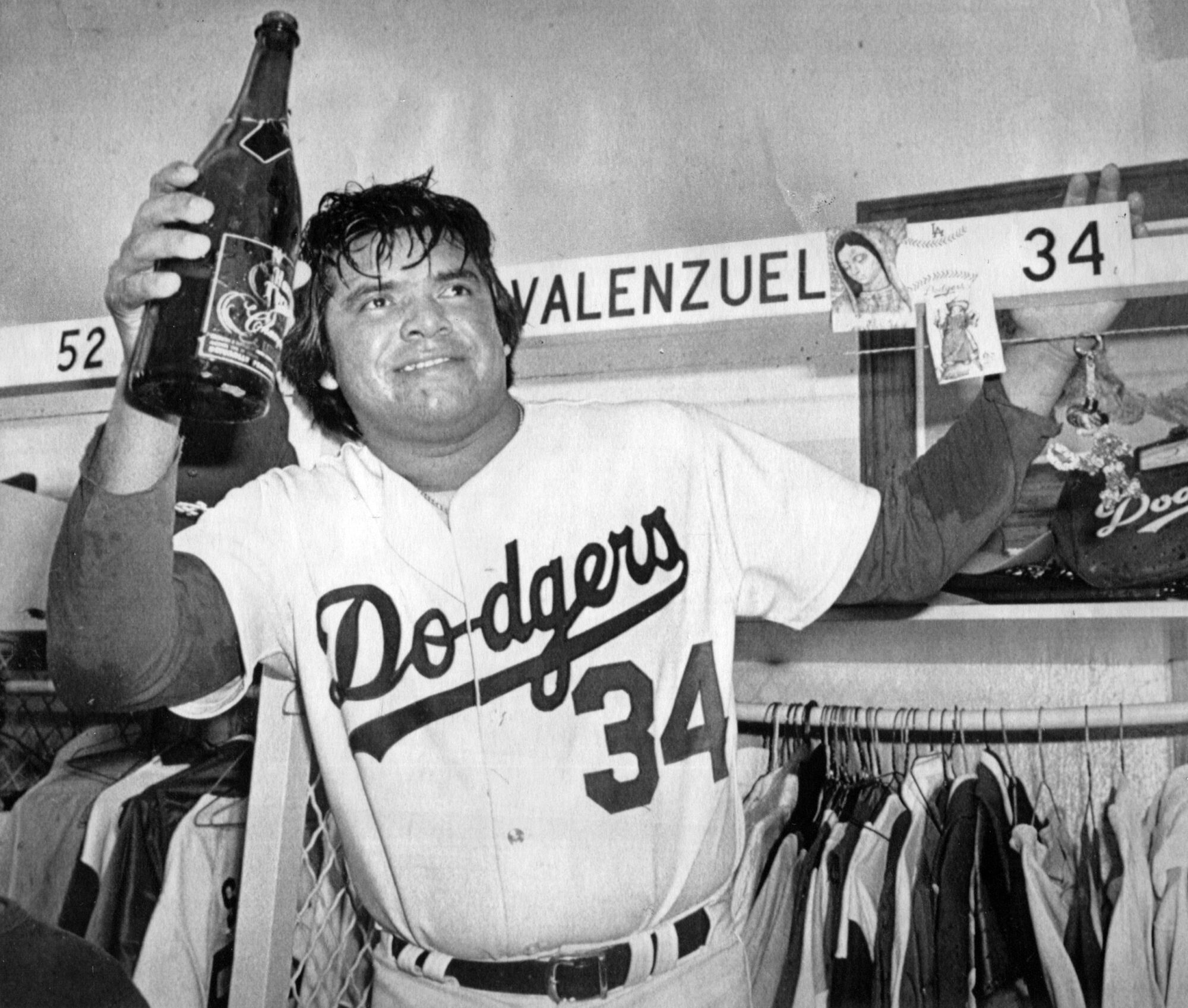 Le lanceur des Dodgers Fernando Valenzuela lève un magnum de champagne lors d'une célébration en 1981.