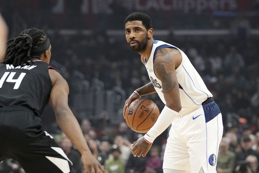 Dallas Mavericks guard Kyrie Irving, right, dribbles as Los Angeles Clippers guard Terance Mann defends during the first half of an NBA basketball game Wednesday, Feb. 8, 2023, in Los Angeles. (AP Photo/Mark J. Terrill)
