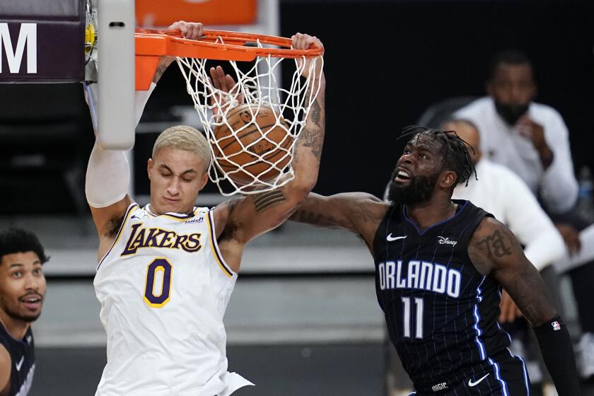 Los Angeles Lakers forward Kyle Kuzma (0) dunks past Orlando Magic forward James Ennis III (11) during the second half of an NBA basketball game Sunday, March 28, 2021, in Los Angeles. (AP Photo/Marcio Jose Sanchez)