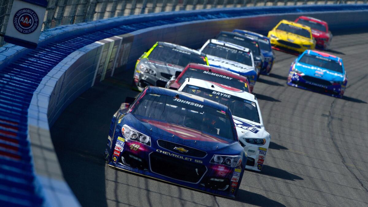 NASCAR driver Jimmie Johnson leads a pack of cars going through a turn during the Auto Club 400 on Sunday.