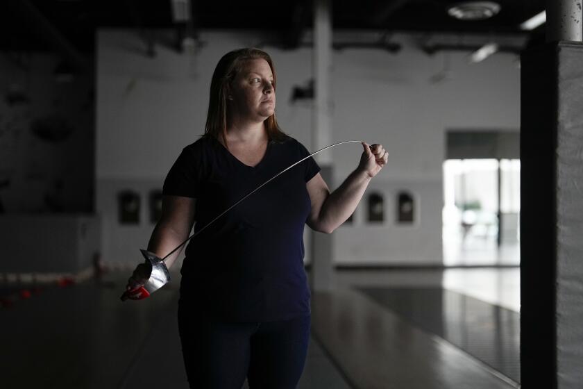 Fencer Kirsten Hawkes poses for a portrait at a fencing studio Tuesday, Sept. 12, 2023, in San Diego. The former elite fencer feels let down by the U.S. Center for SafeSport after filing a complaint to the agency formed six years ago to combat sexual misconduct in Olympic sports. Hawkes’ former coach, who she accused of forcing an unwanted kiss on her and other abuse, never went on a list of the agency's disciplinary database — not after SafeSport handed him a three-month probation, nor after the probation was overturned by an arbitrator. (AP Photo/Gregory Bull)