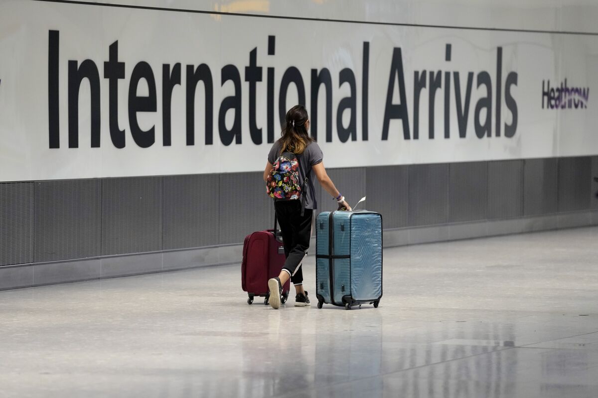  In this Monday, Aug. 2, 2021 file photo, a passenger arrives from a flight at Terminal 5