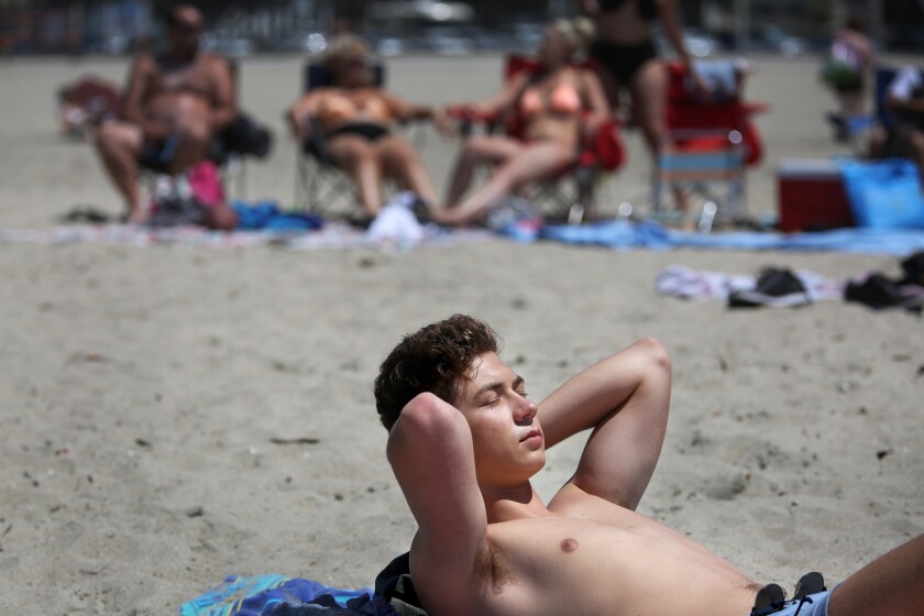 Jack Amsbry, 18, of Pasadena enjoys a warm beach breeze on Sunday in Long Beach.