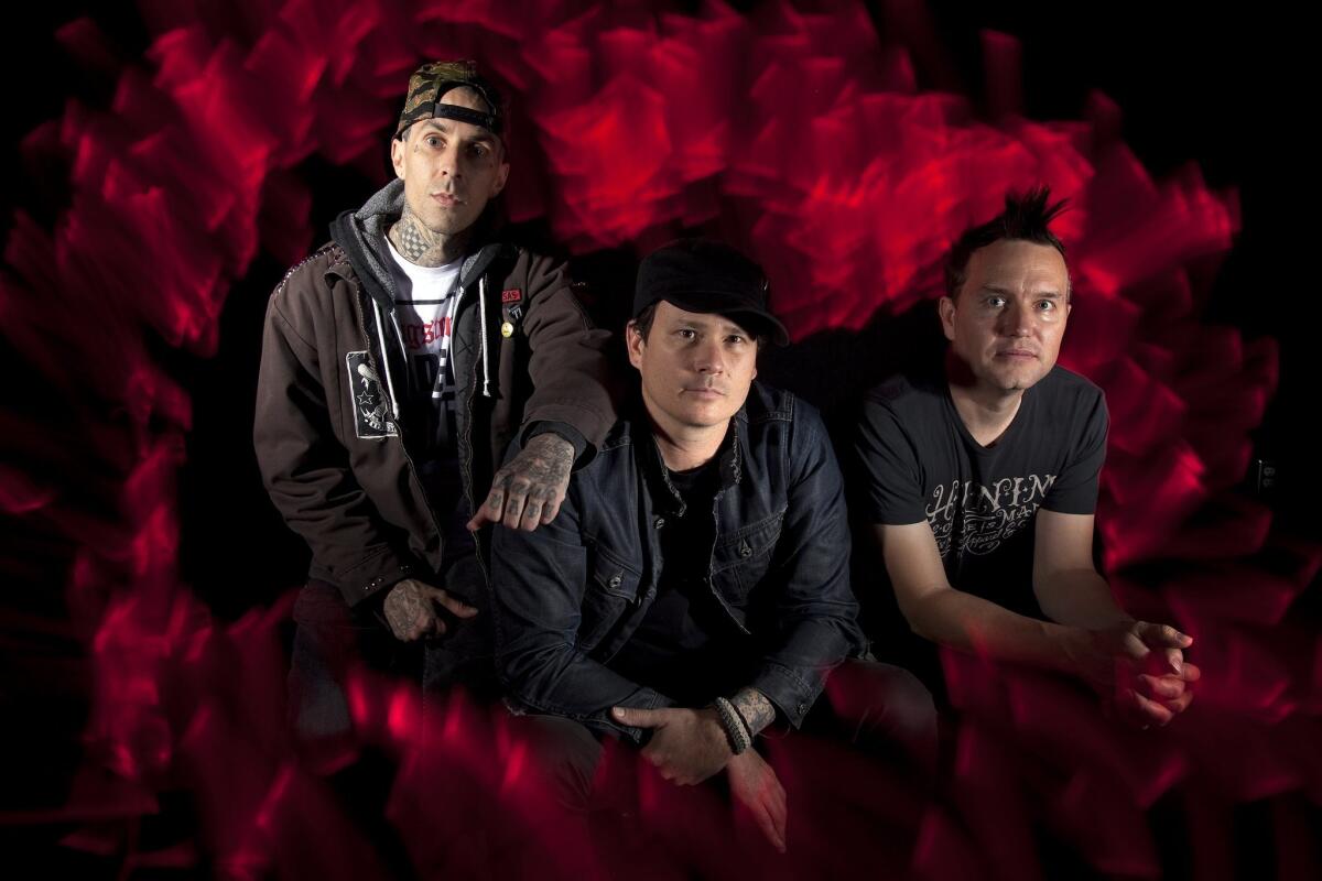 Travis Barker, left, Tom DeLonge and Mark Hoppus are the original members of Blink-182. Despite what his bandmates say, DeLonge insists he is still a member of the band.