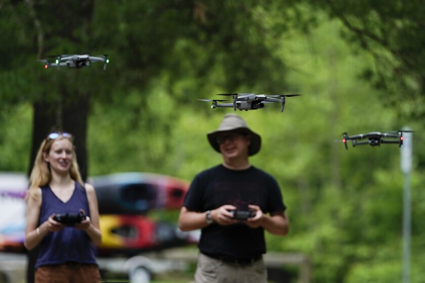 Quincey Johnson, left, outreach director Upper Missouri Waterkeeper in Bozeman, Mont., and Martin Lizely, Grand Riverkeeper with LEAD Agency in Miami, Okla., fly their drones during a training session, Tuesday, June 7, 2022, in Poolesville, Md. They work to protect rivers and waterways and are training to use drones to catch polluters in places where wrongdoing is difficult to see or expensive to find. The Waterkeeper alliance has already used drone images to formally accuse companies of wrongdoing. (AP Photo/Julio Cortez)
