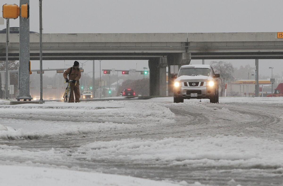 Jeff Chupp walks his ice covered bike along Great Southwest Parkway in Grand Prairie, Texas. A large ice storm causing travel problems and power outages moved through the Dallas, Texas area and across the midwest.