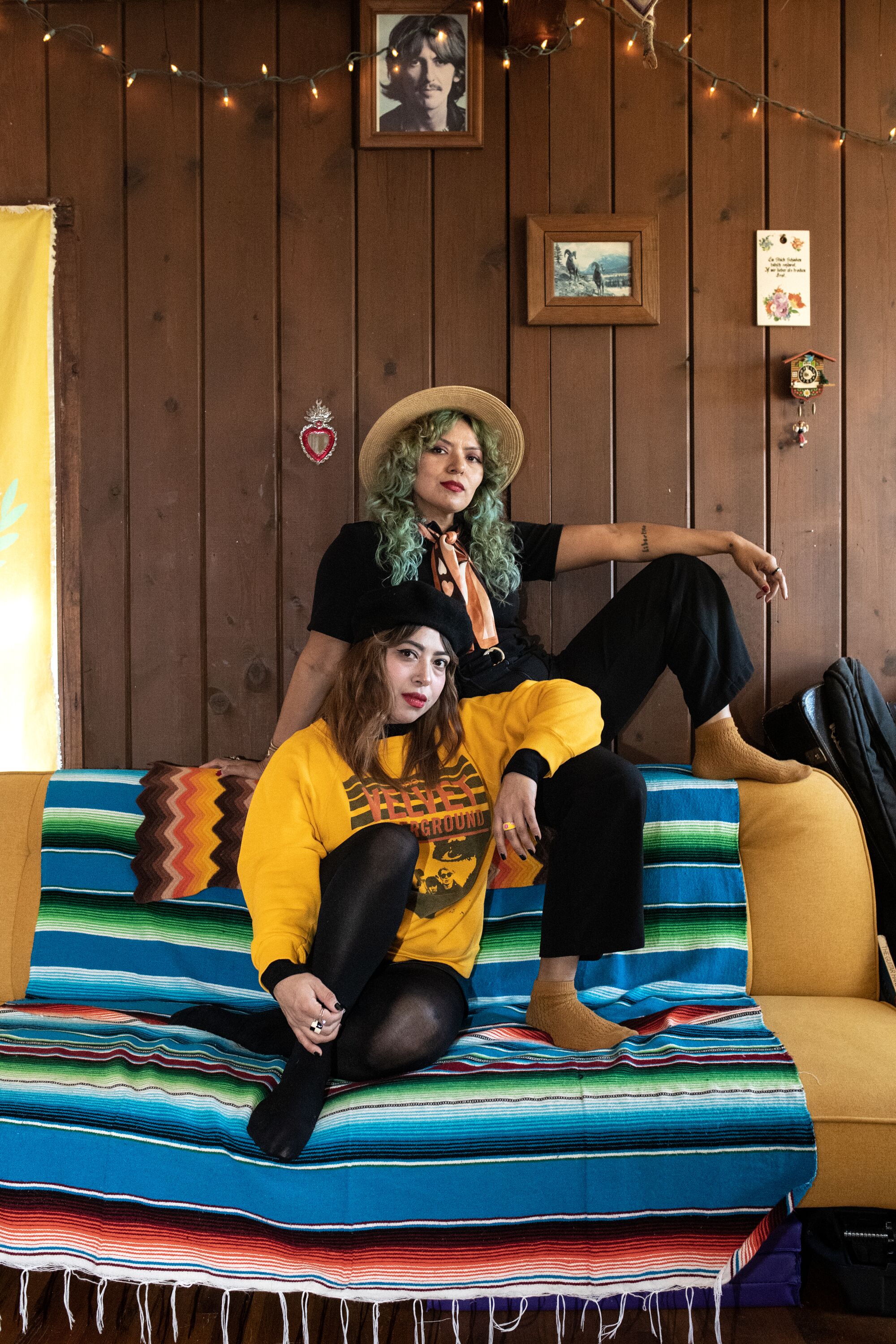 Ursula and Rebecca Recinos pose on a couch.
