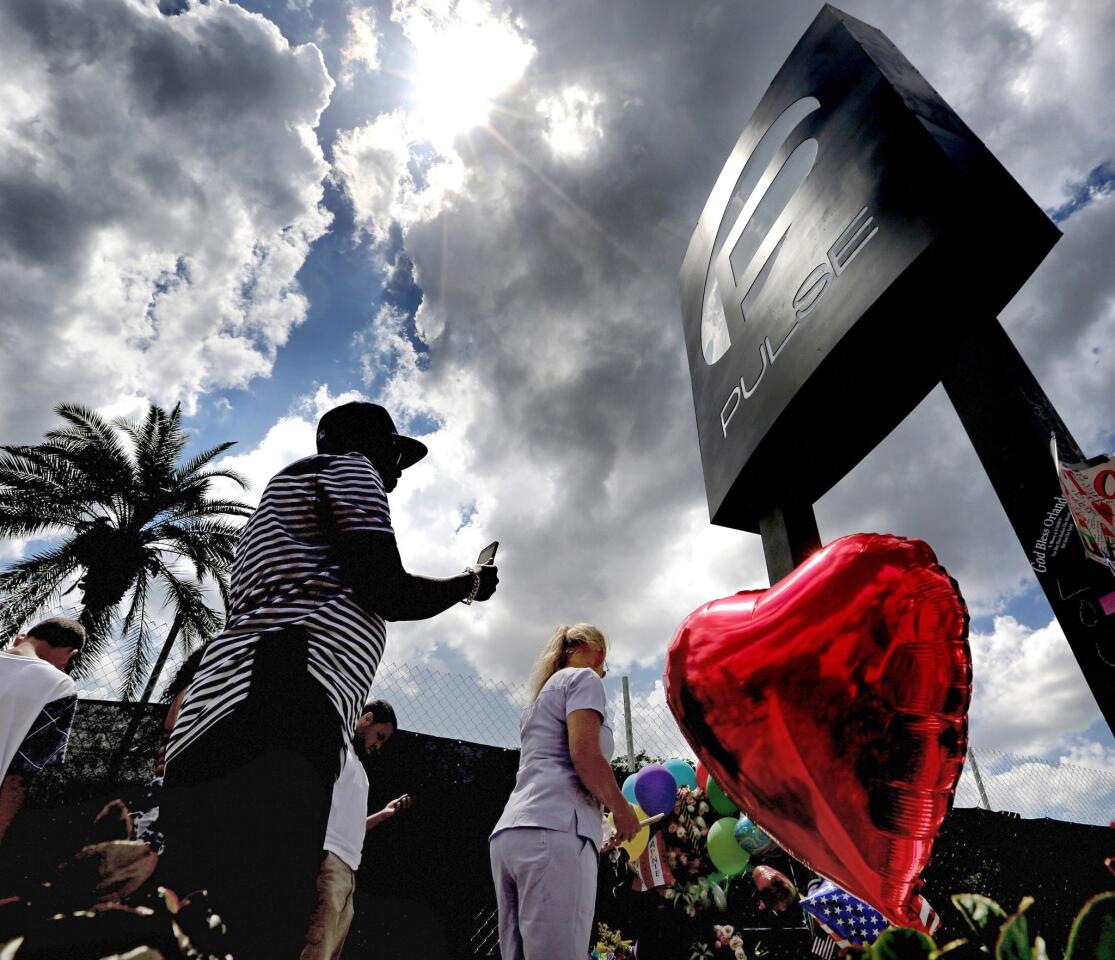 Visitors pay their respects at a memorial in front of the Pulse nightclub June 23, 2016, in Orlando, Fla.