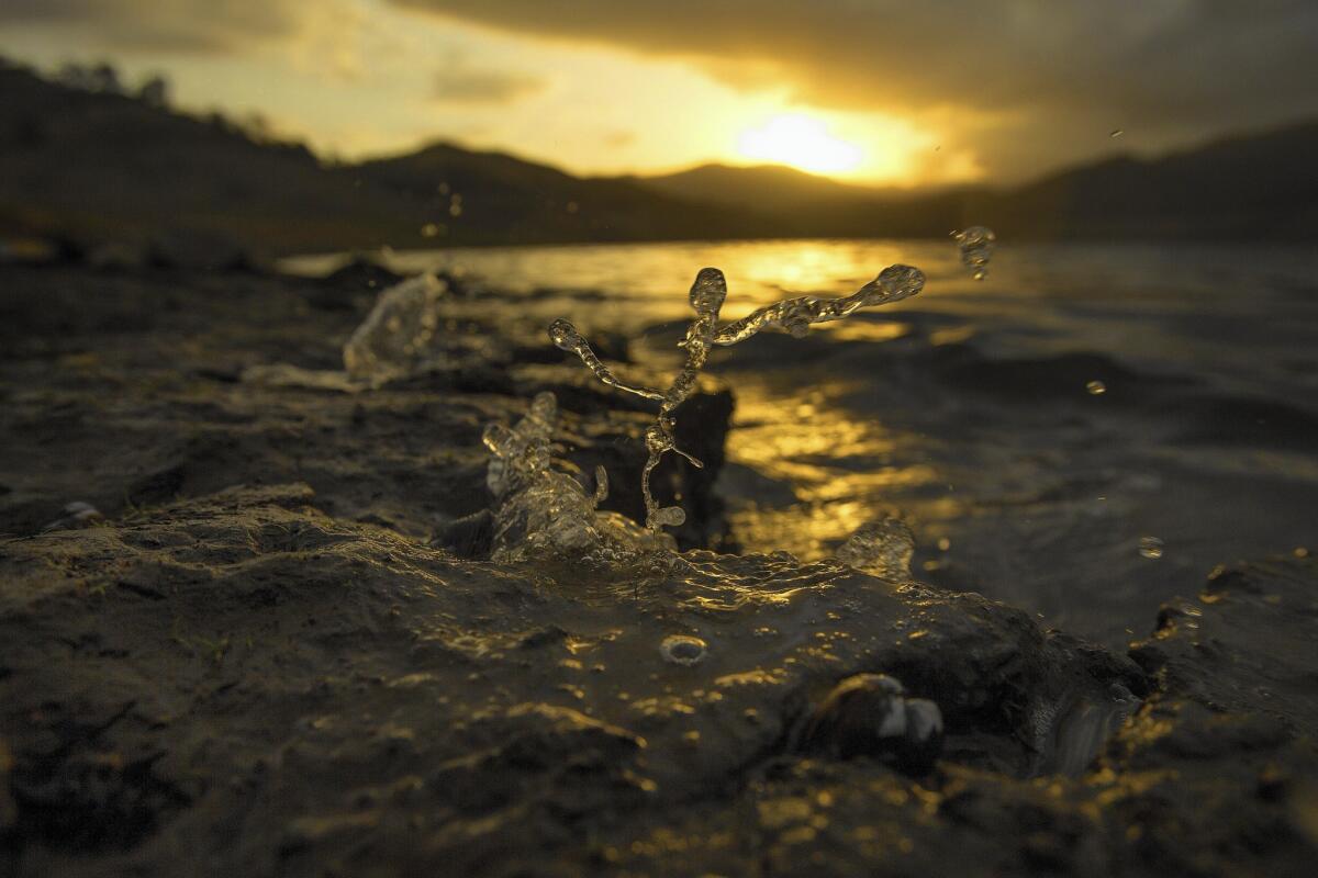 At sunrise, wind pushes the receding water to splash up on the banks at Pine Flat Reservoir in Sanger, Calif.