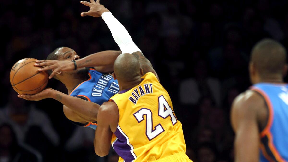 Lakers guard Kobe Bryant pressures Thunder forward Kevin Durant as he tries to beat the shot clock on Wednesday night.