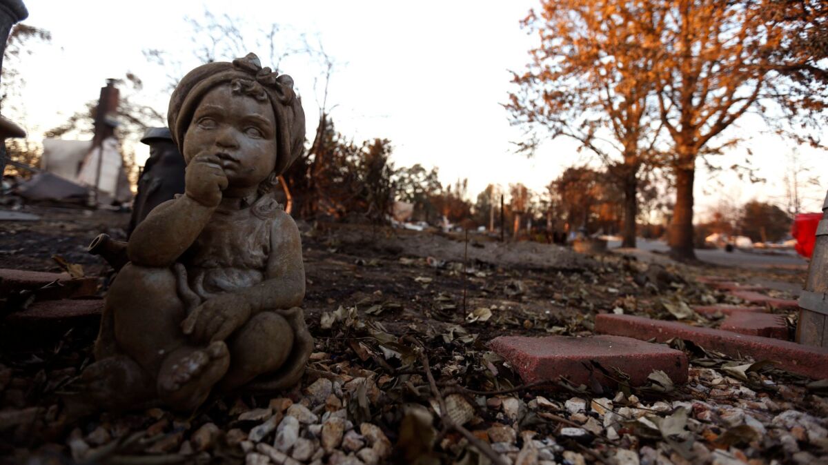 A sculpture of a child rests in the fire ravaged neighborhood of Coffey Park in Santa Rosa.