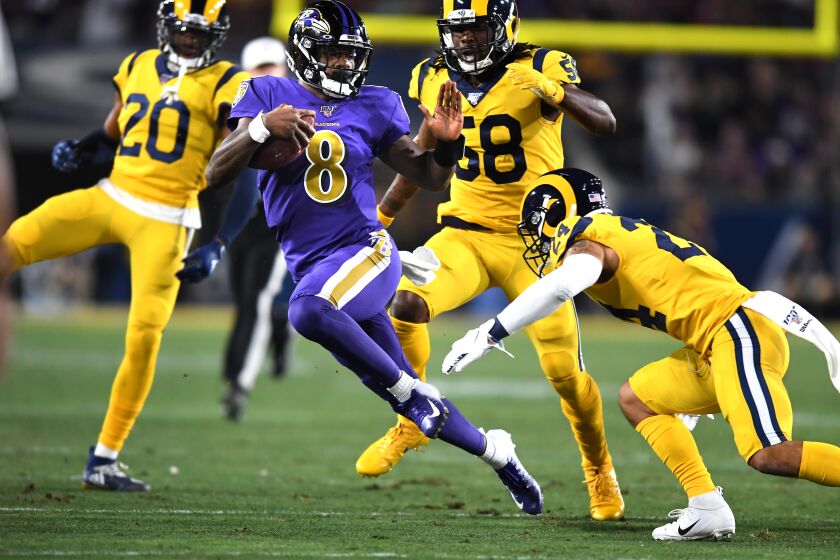 LOS ANGELES, CALIFORNIA NOVEMBER 25, 2019-Ravens quarterback Lamar Jackson picks up big yards against Rams from left, Jalen Ramsey, Cory Littleton and Taylor Rapp in the 1st quarter at the Coliseum Sunday. (Wally Skalij/Los Angerles Times)