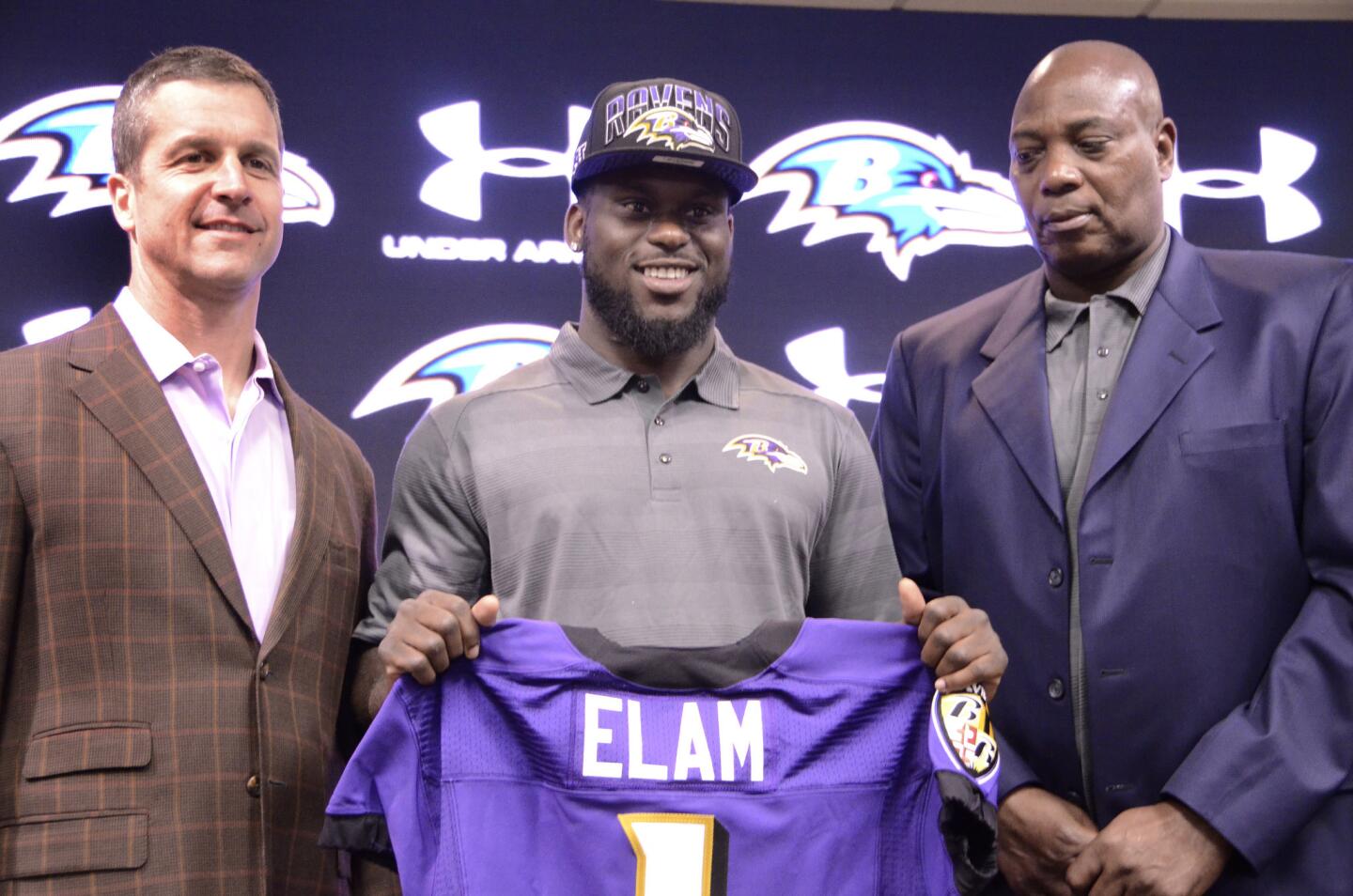 Ravens coach John Harbaugh and general manager Ozzie Newsome pose for pictures with first-round draft pick Matt Elam.