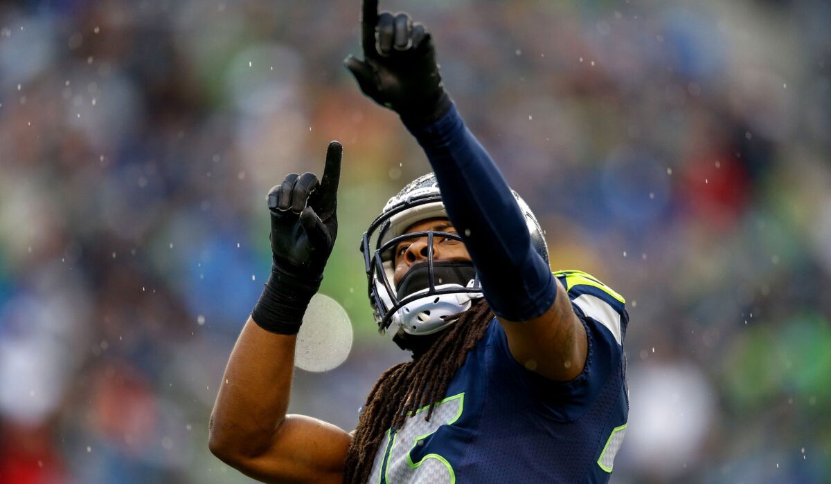 Cornerback Richard Sherman points toward Seahawks fans in the stands at CenturyLink Field during a game against the Raiders.