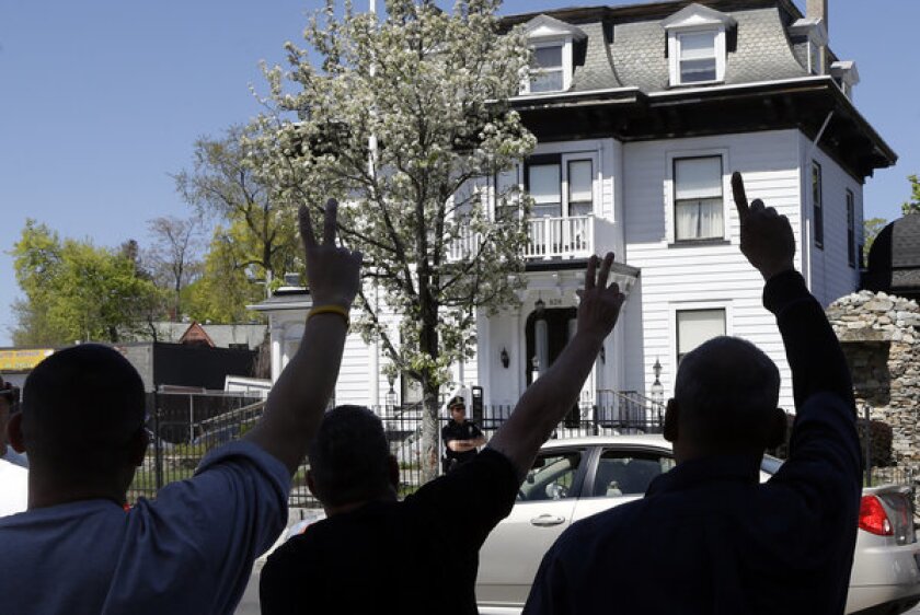 Protesters gesture outside the Graham, Putnam, and Mahoney Funeral Parlors in Worcester, Mass., where the body of killed Boston Marathon bombing suspect Tamerlan Tsarnaev is being prepared for burial.