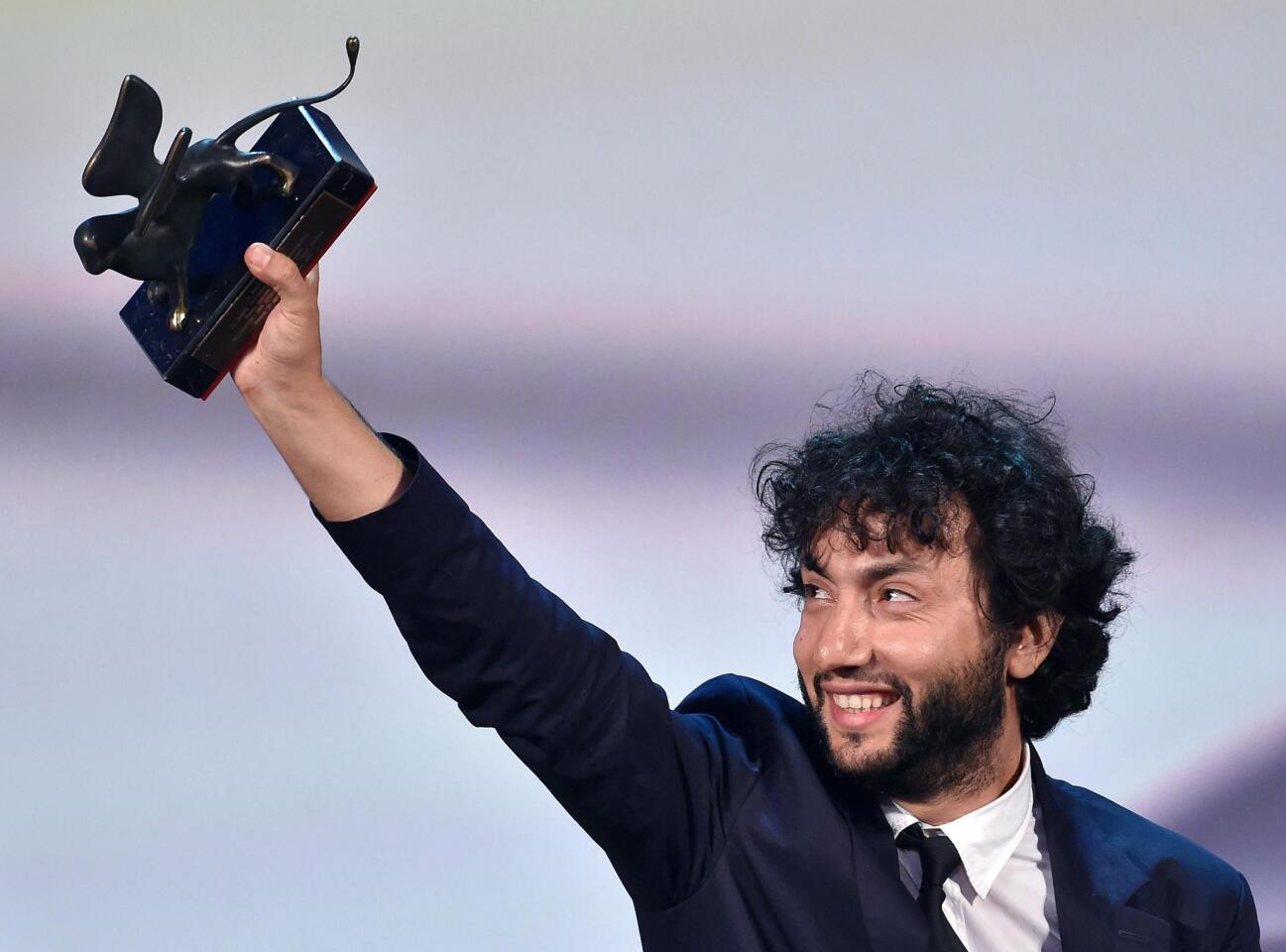 Turkish director Kaan Mujdeci holds the jury award for his movie "Sivas" at the festival.