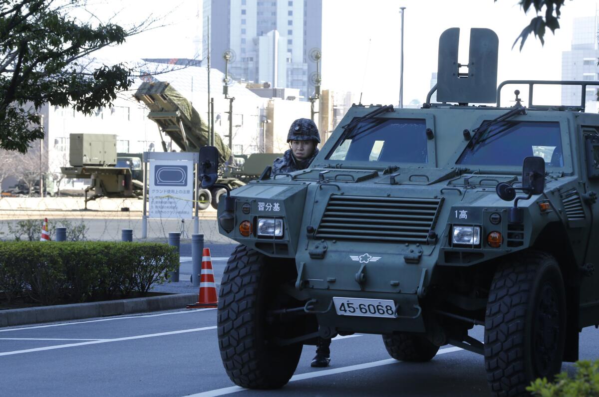 A member of the Japan Self-Defense Forces stands near a PAC-3 Patriot missile unit deployed for North Korea's rocket launch at Defense Ministry in Tokyo, Sunday, Feb. 7, 2016.