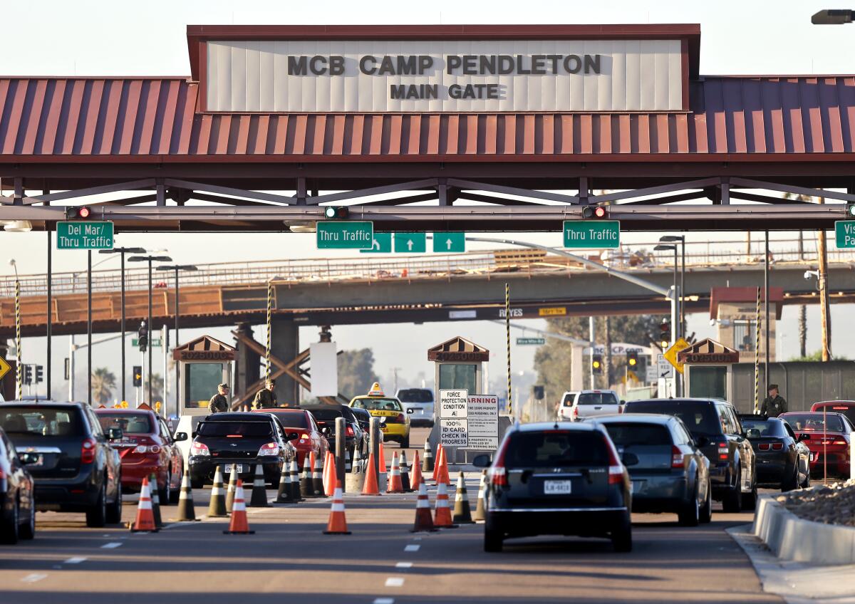 An entrance to Camp Pendleton in Oceanside with cars lined up to enter