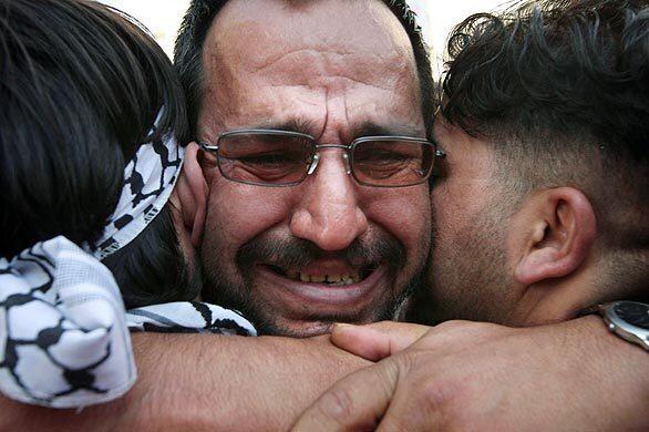 A Palestinian who was among 224 prisoners released by Israel hugs relatives on arrival in the West Bank city of Ramallah on Monday.