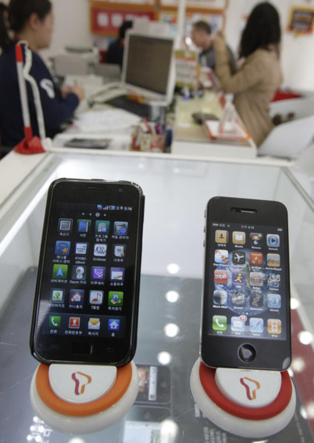 A federal judge denied Apple's request to increase its $1-billion patent infringement judgment against Samsung. Above, a Samsung Galaxy S smartphone, left, and Apple's iPhone 4 at a store in Seoul in 2011.