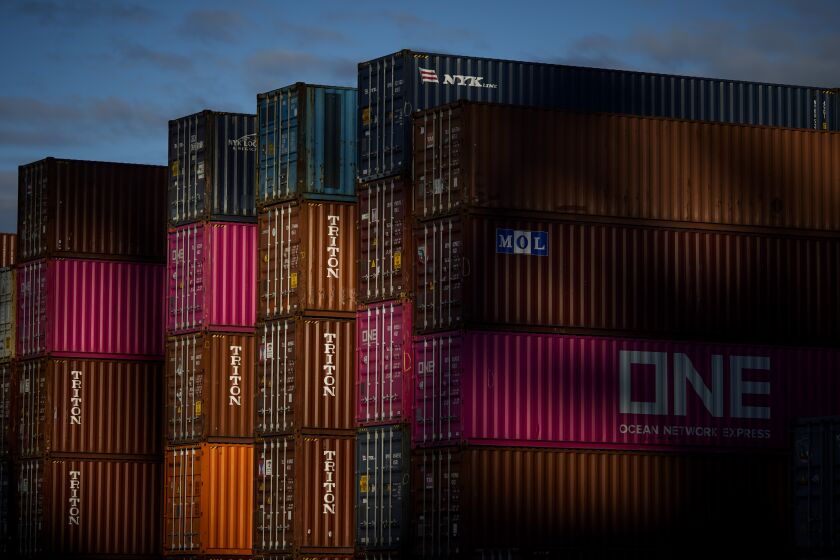 WILMINGTON, CALIF. - DECEMBER 18: Sunlight washes across shipping containers stacked at the TraPac terminal where longshoremen work on plugging in the YM Movement to the terminals power so that the ship won’t have to run off of generators while docked at the Port of LA on Wednesday, Dec. 18, 2019 in Wilmington, Calif. (Kent Nishimura / Los Angeles Times)