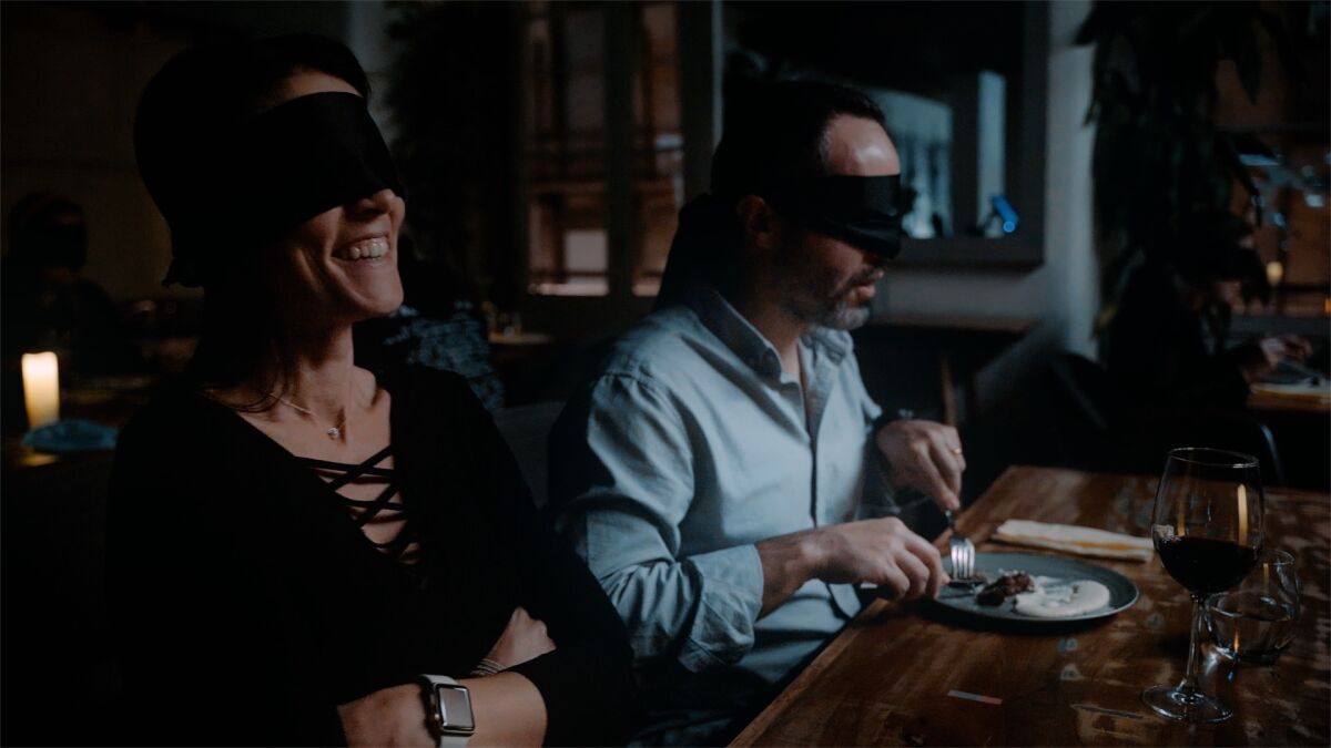 A couple experiences Dining in the Dark, an experiential concept coming to San Diego in May.