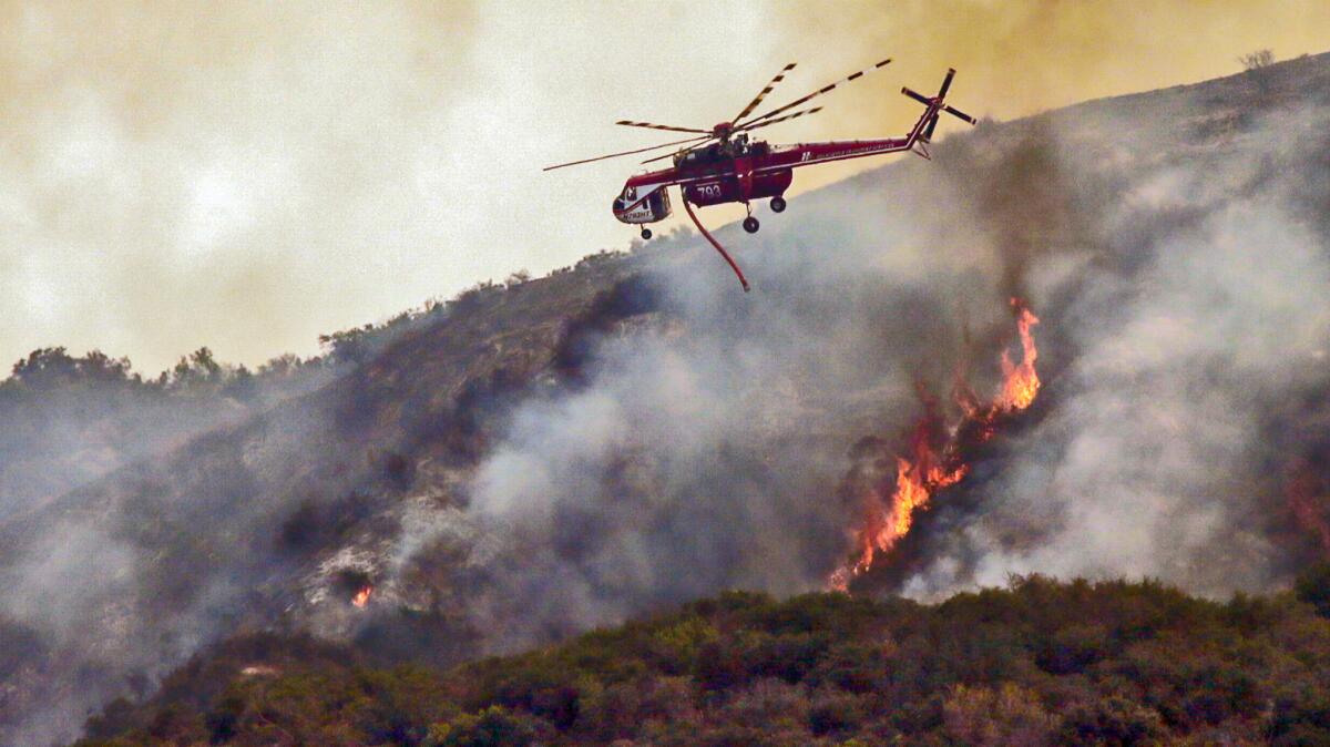 L.A. County Fire helicopters continue making water drops on parts of the San Gabriel Complex fire above Duarte.