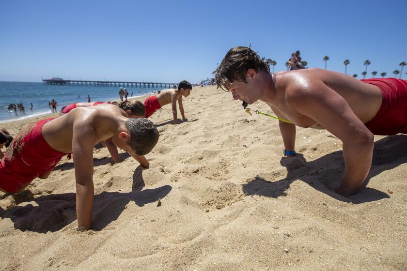 Newport Beach, CA - June 21: Zach Kittleson, right, does pushups with his group of junior lifeguards on Tuesday, June 21, 2022 in Newport Beach, CA. (Scott Smeltzer / Daily Pilot)
