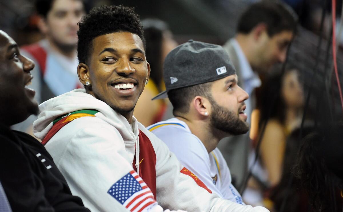 Lakers teammates Nick Young, left, and Jordan Farmar attend a USC-UCLA men's basketball game in February. They made more sporting rounds this week.