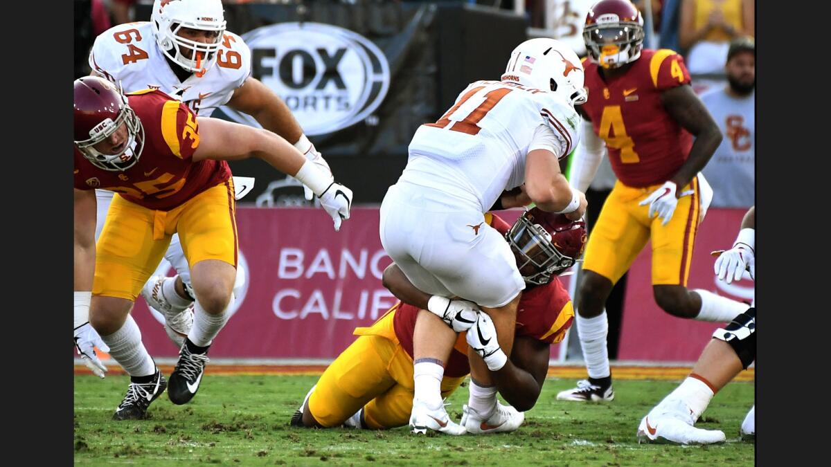 USC linebacker Uchenna Nwosu stops Texas quarterback Sam Ehlinger on fourth down during the first quarter of a game at the Coliseum.