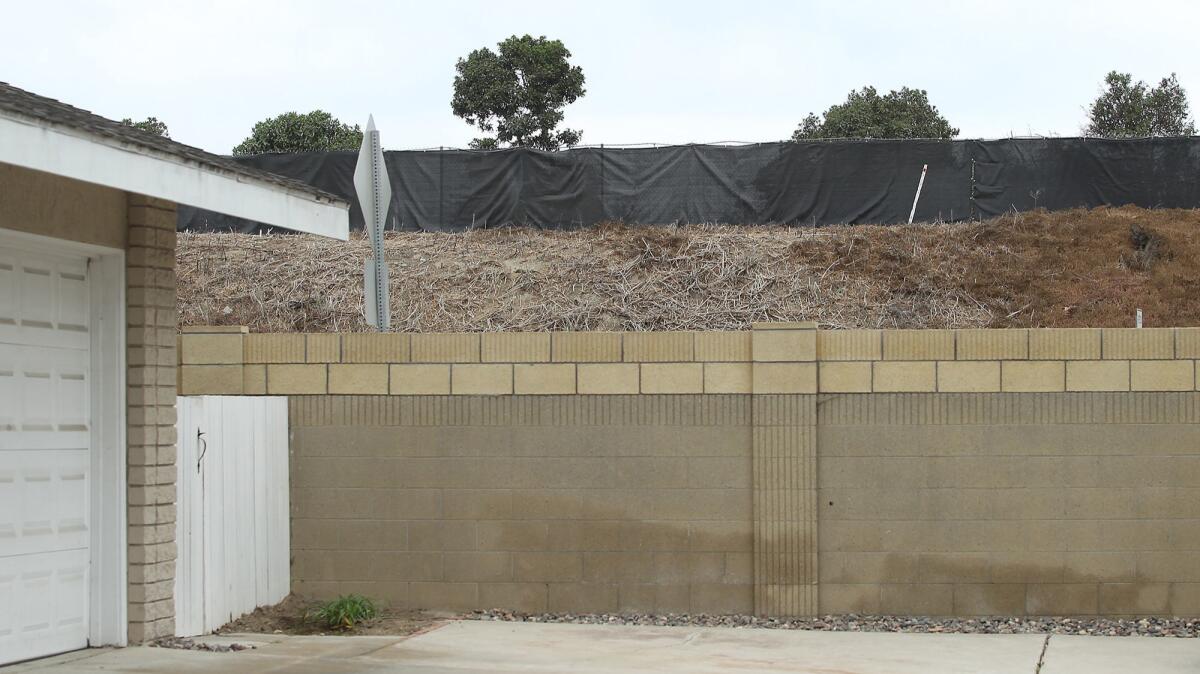 Neighbors of the former Ascon landfill say black dust flows downwind over the site’s dark-colored fence onto their homes, cars and plants.