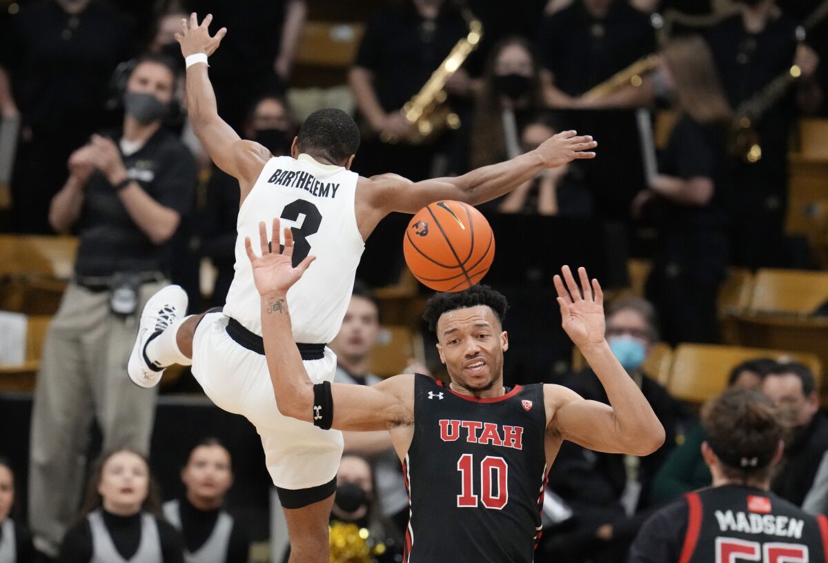 Colorado guard Keeshawn Barthelemy (3) leaps by Utah guard Marco Anthony who passes the ball in the second half of an NCAA college basketball game Saturday, Feb. 12, 2022, in Boulder, Colo. (AP Photo/David Zalubowski)