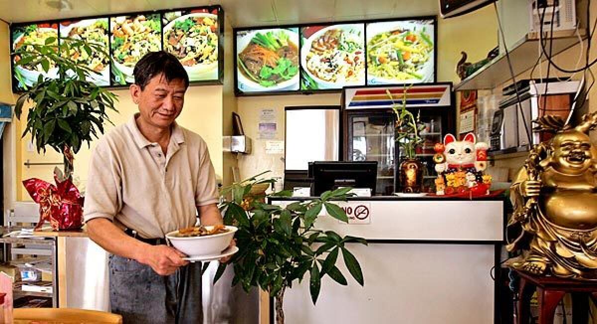 Happy Kitchen's owner and chef, Jixian Liang, prepares to serves a specialty of the house.