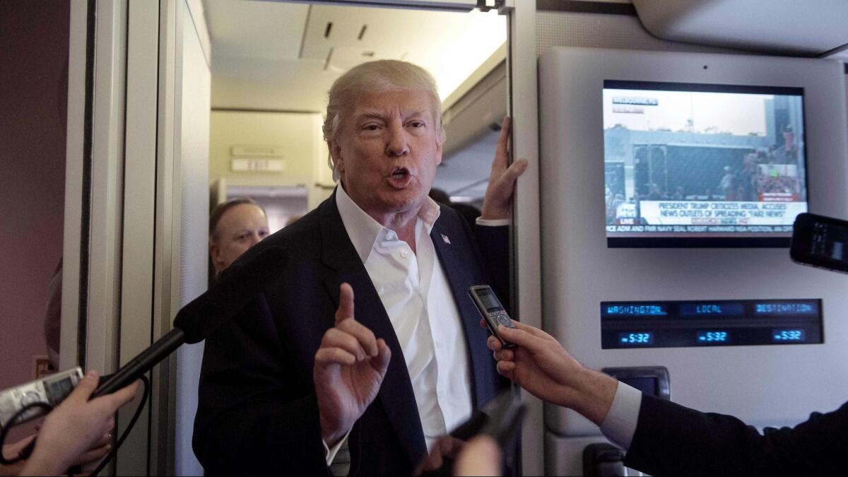 President Trump speaks to reporters aboard Air Force One on Feb. 18.