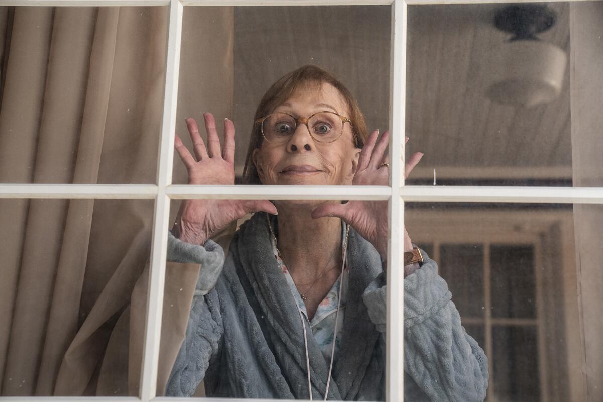 An older woman peers out of a window in "Better Call Saul." 